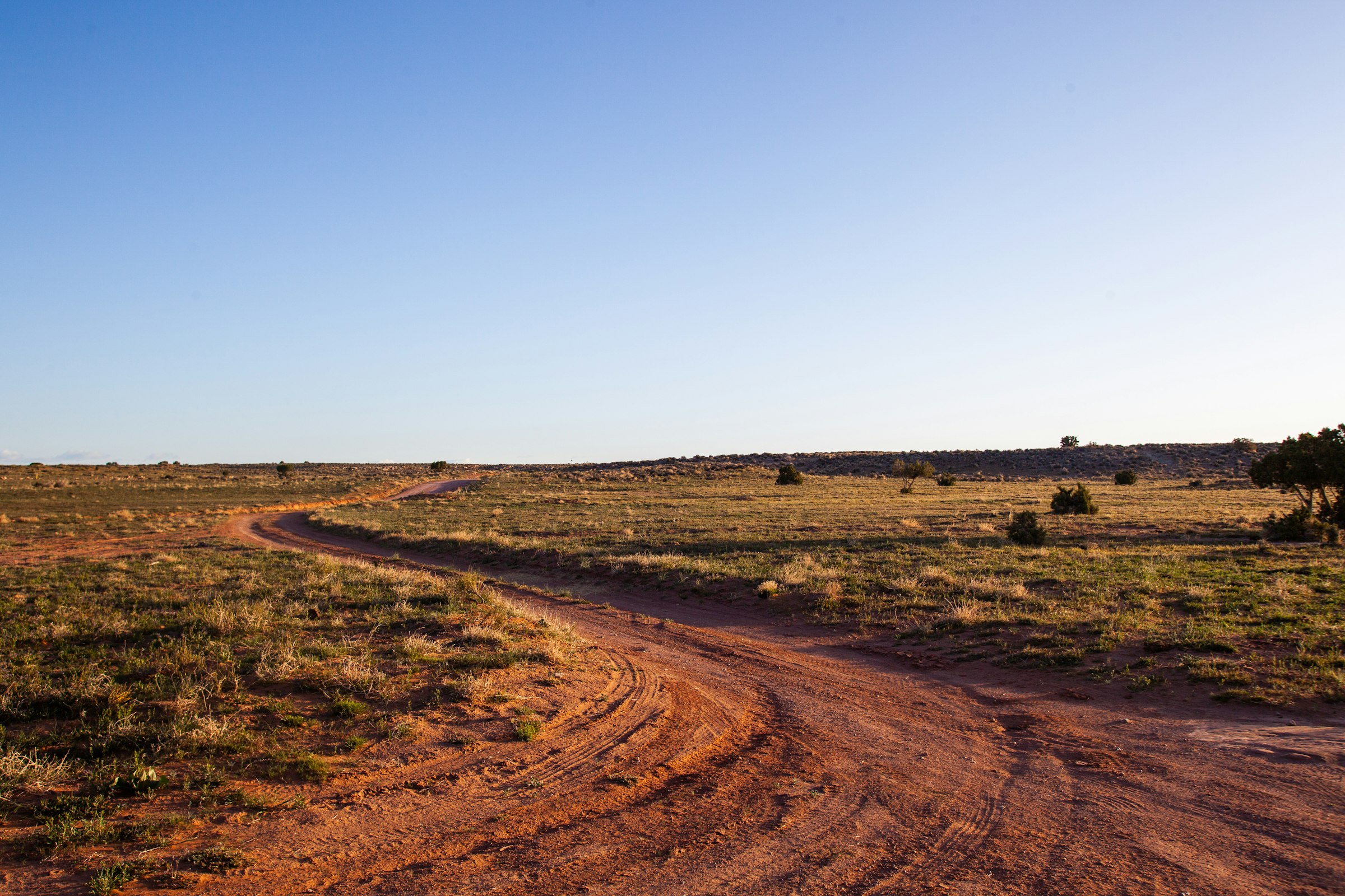 The dirt road in across the grassland