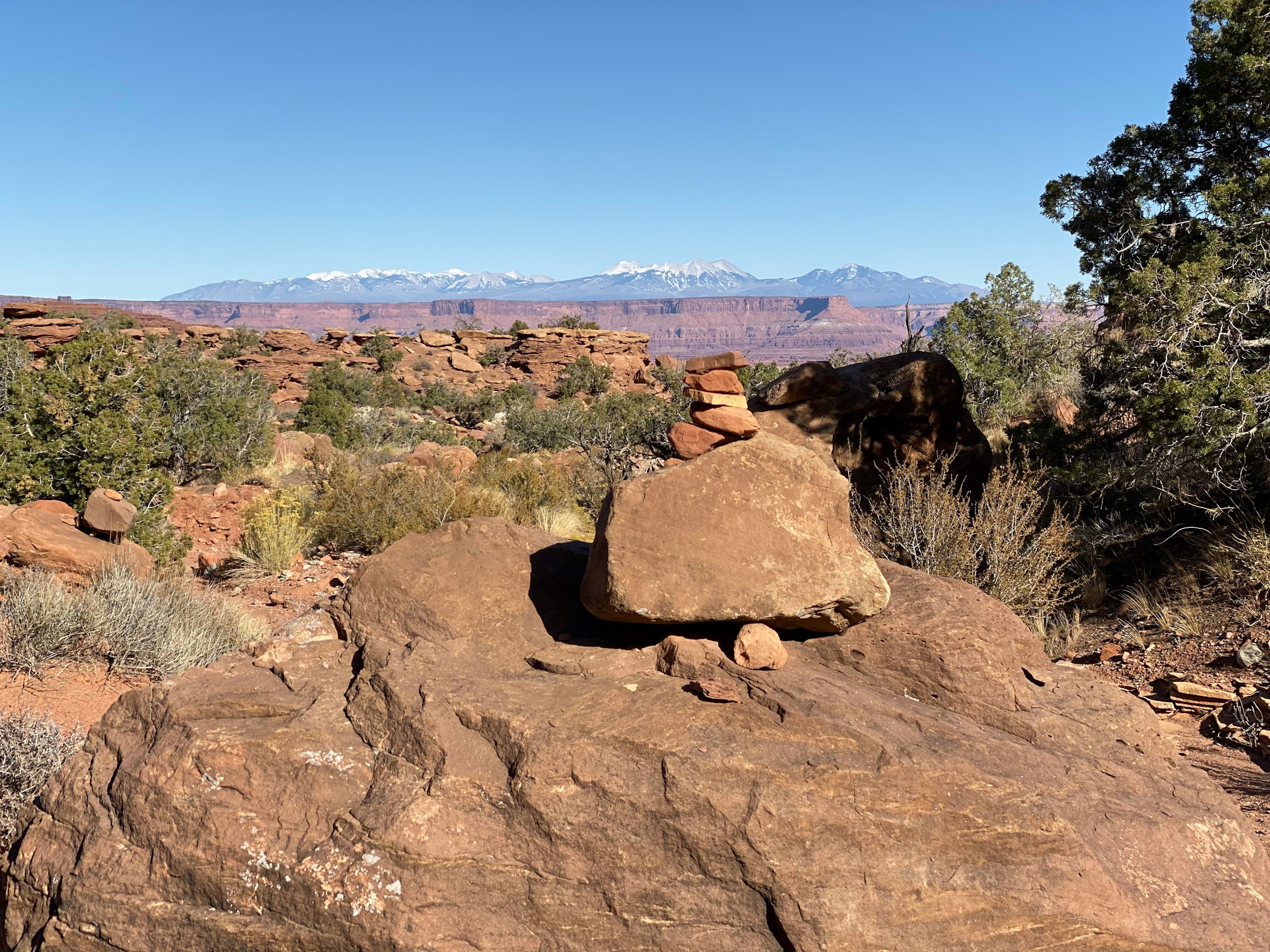 A cairn on the route with the La Sal Mountains behind