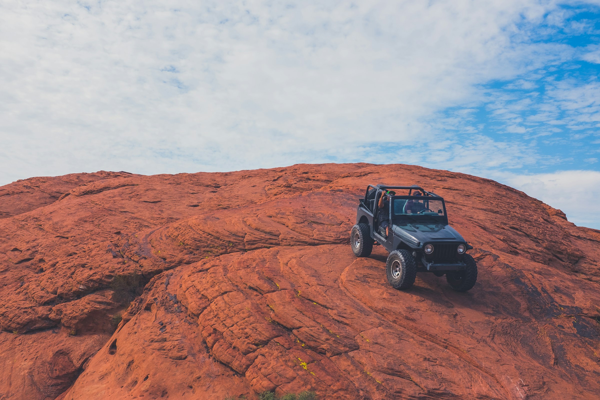 A jeep climbing open slickrock